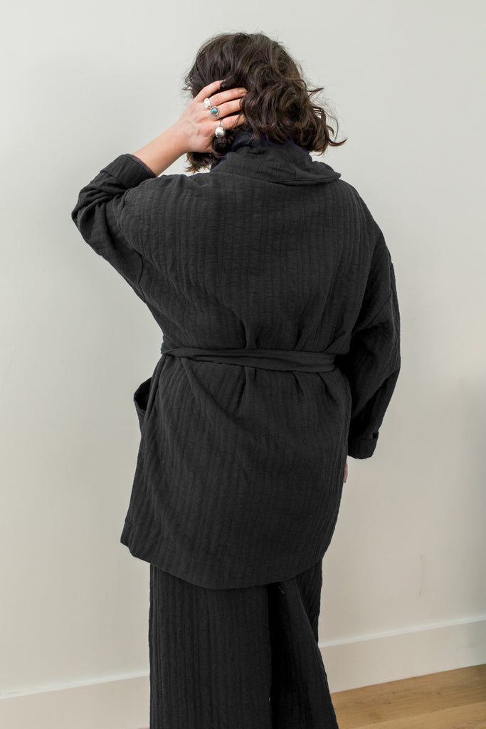 Back view of Sadie Coat in Black on model in front of white wall