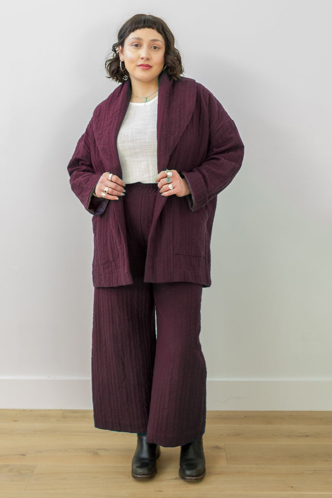 Front view of model wearing Sadie Coat in Burgundy, Ayana Top in White, and Dover Pant in Burgundy, in front of white background