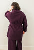 Back view of model wearing Sadie Coat in Burgundy and Dover Pant in Burgundy, with one hand on head in front of white background