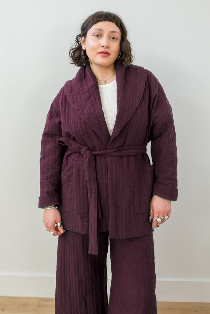 Front view of model wearing a belted Sadie Coat in Burgundy, Ayana Top in White, and Dover Pant in Burgundy, in front of white background