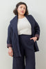 Front view of model wearing Sadie Coat in Indigo, Ayana Top in White, and Dover Pant in Indigo, with one hand in pocket in front of white background