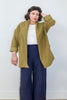Front view of model wearing Sadie Coat in Fennel, Ayana Top in White, and Dover Pant in Indigo, in front of white background