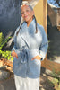 Model wearing a stone blue Sadie Coat  standing outdoors.
