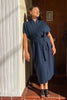 Vela Caftan in Peacoat with tie belt on model leaning against white wall