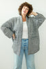 Model wearing Sloane Coat in Black/White and light wash jeans in front of white wall