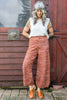Model wearing Minnie Tank in white and Sofie Sweater Pants in Rust Melange in front of wooden structure