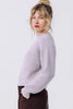 Side view of model wearing Sonnie Sweater in Mist and Atlas Pant in Chocolate with one hand in pant pocket in front of white background