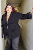 Model wearing Stevie Sweater in Black standing in long building hallway