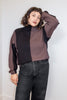 Front view of model wearing Sybil Vertical Stripe Sweater in Peppercorn/Black and black jeans, standing with one hand on head in front of white background