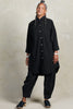 Front view of model wearing Workshirt and Cadence Pant both in Black, in front of white background