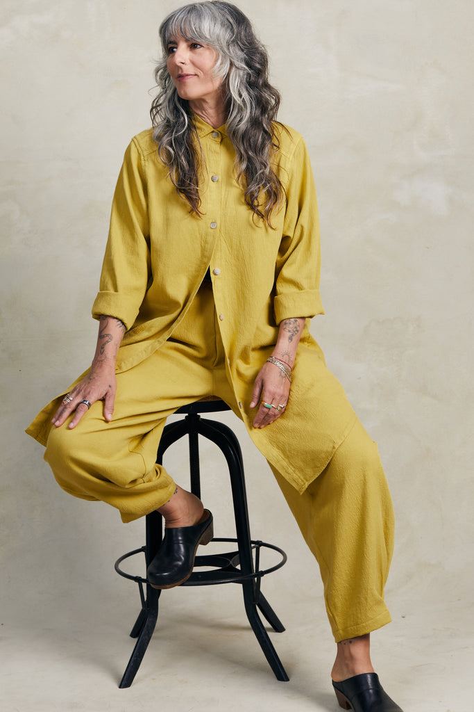 Cadence Pant in Dijon paired with Workshirt in Dijon on model sitting on black stool in front of white background