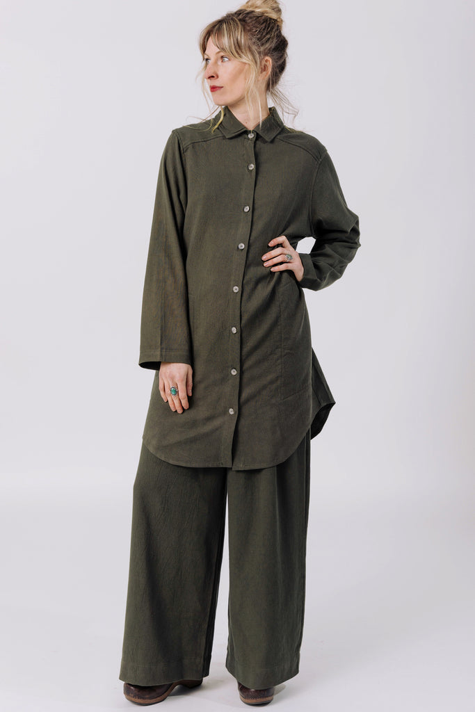 Front view of model wearing Workshirt and Atlas Pant, both in Mud, standing with hand on hip in front of white background