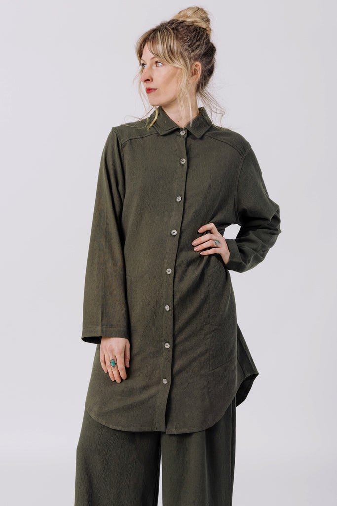 Model wears Workshirt in Mud and Atlas Pant in Mud, standing with one hand on hip, in front of white background