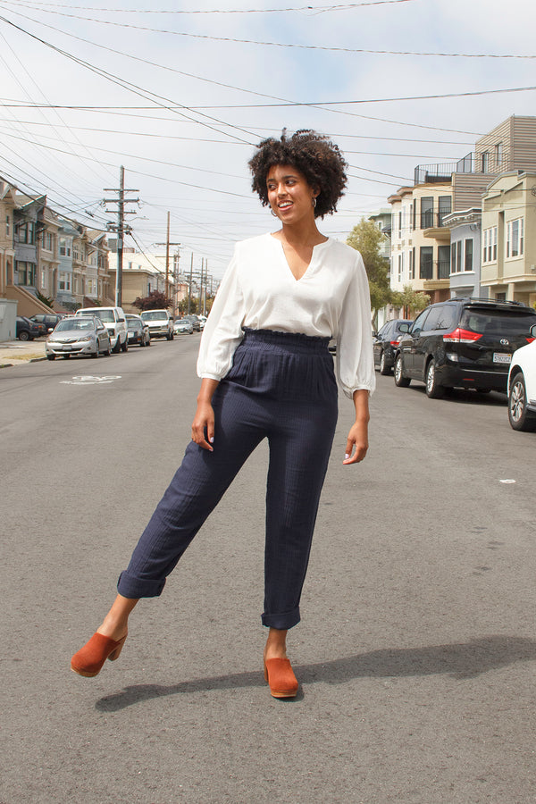 model posing in street in elastic waist pants and flowing white blouse